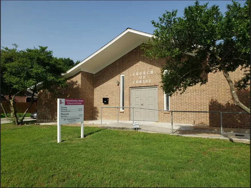 A brick building with a sign in front of it.