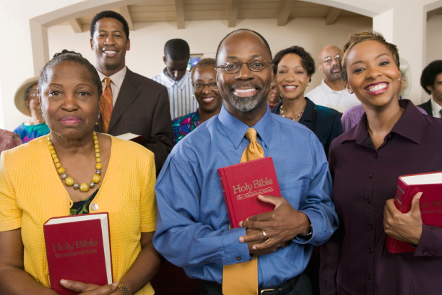 A group of people holding books and smiling.